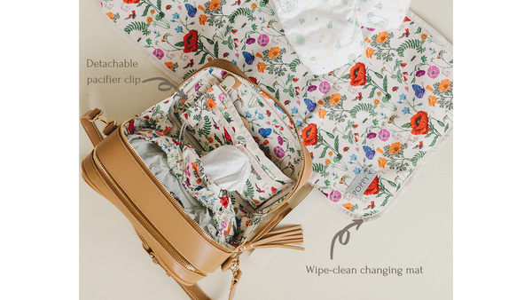 Photo of interior of the Poppy bag, highlighting the detachable pacifier clip and showing the optional wipe-clean changing mat.